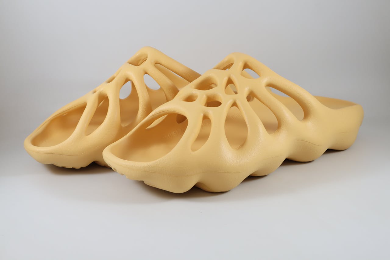 who-we-are Stylish 3D-printed beige slippers with unique design on a white background.